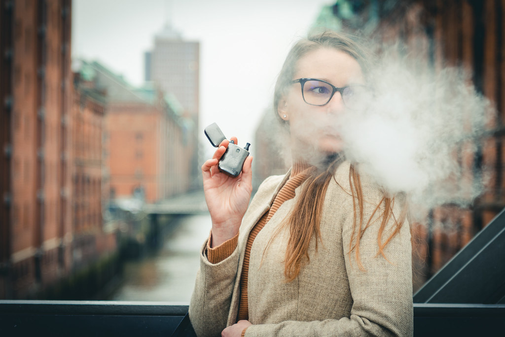 Woman holding a vape device outdoors